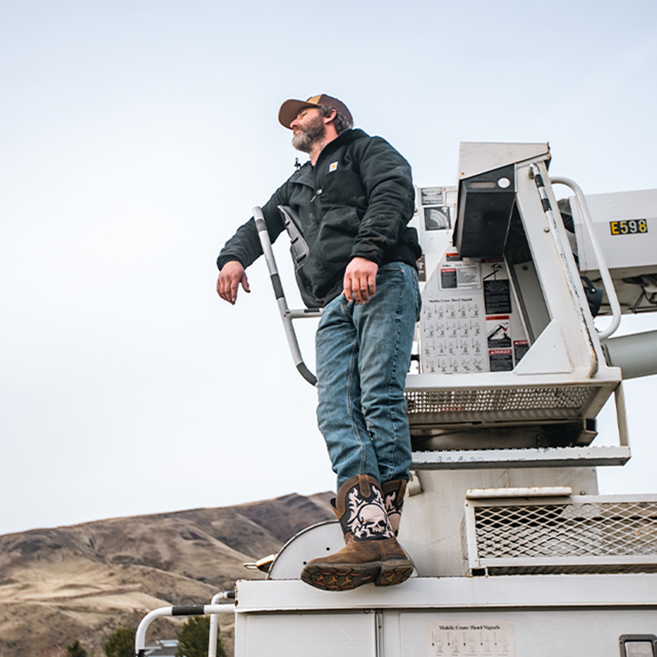 A man standing on top of a boat wearing Double-H boots in brown.