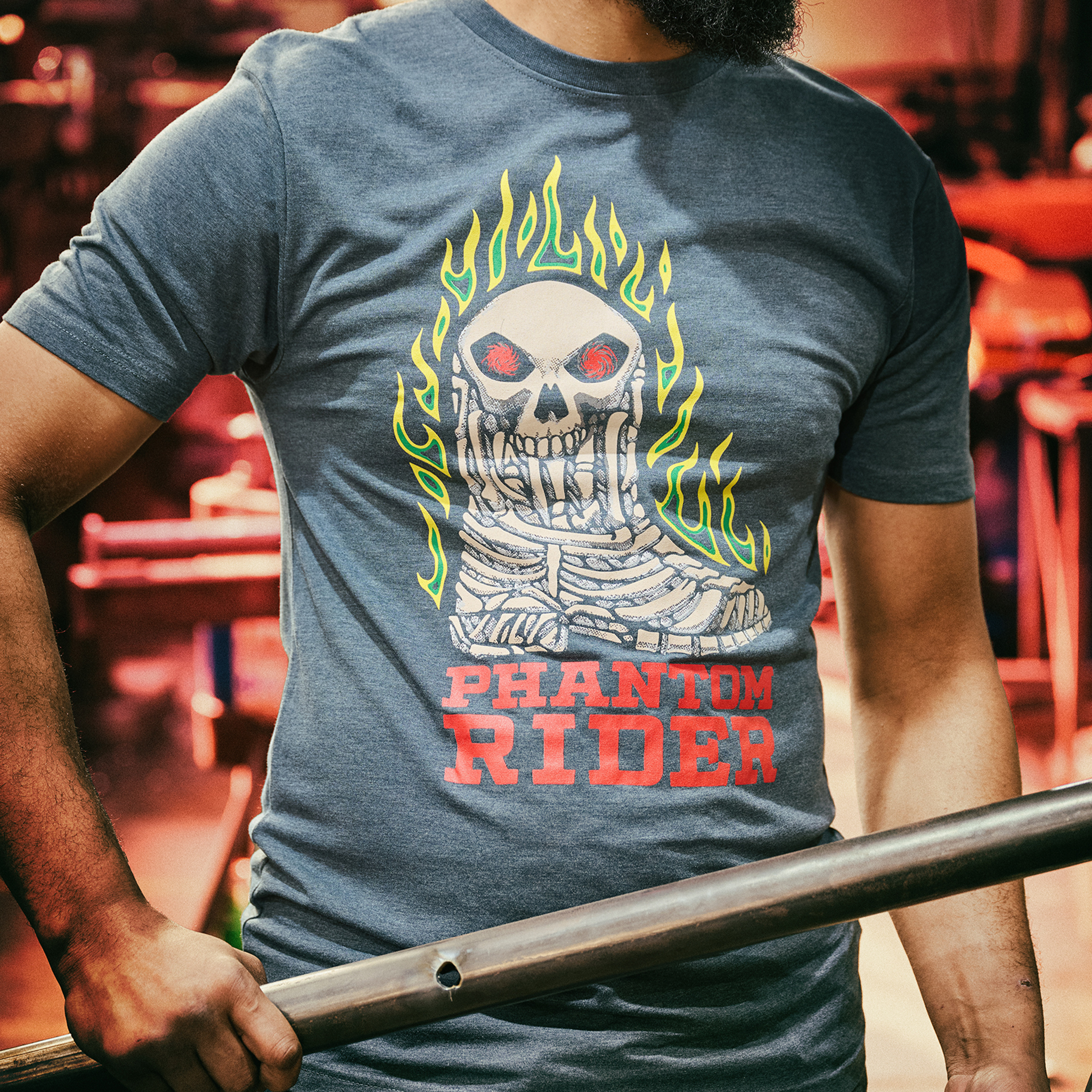 A man wearing the Phantom Rider Sharp Shooter Tee in blue.