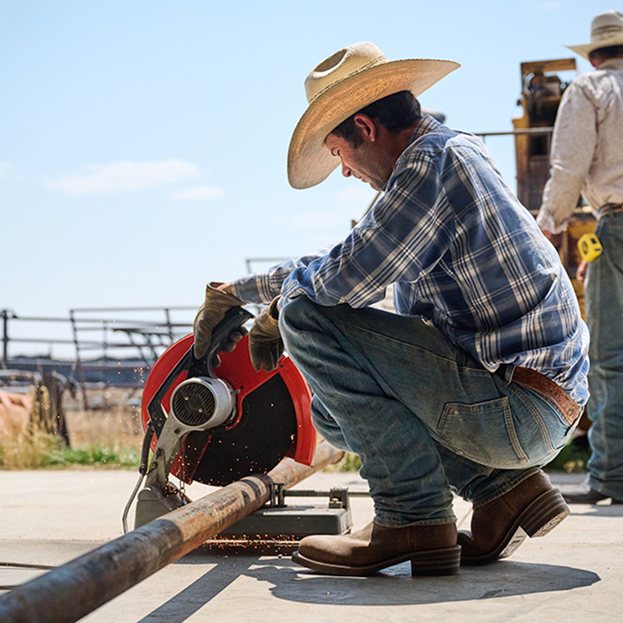 A cowboy working wearing the Garza comp toe western boot in brown.