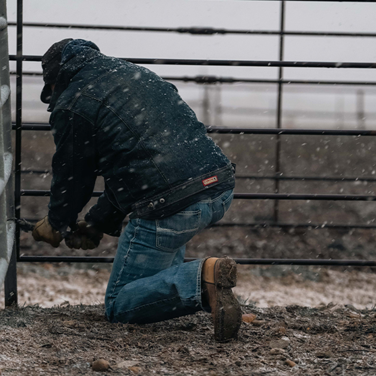 A man working on a farm wearing Double-H Boots.