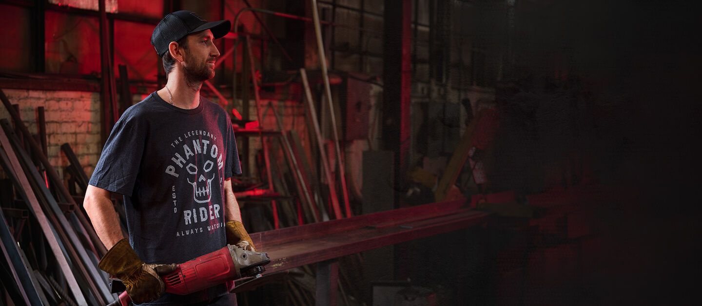 Man in black Phantom Rider T-shirt in workshop.