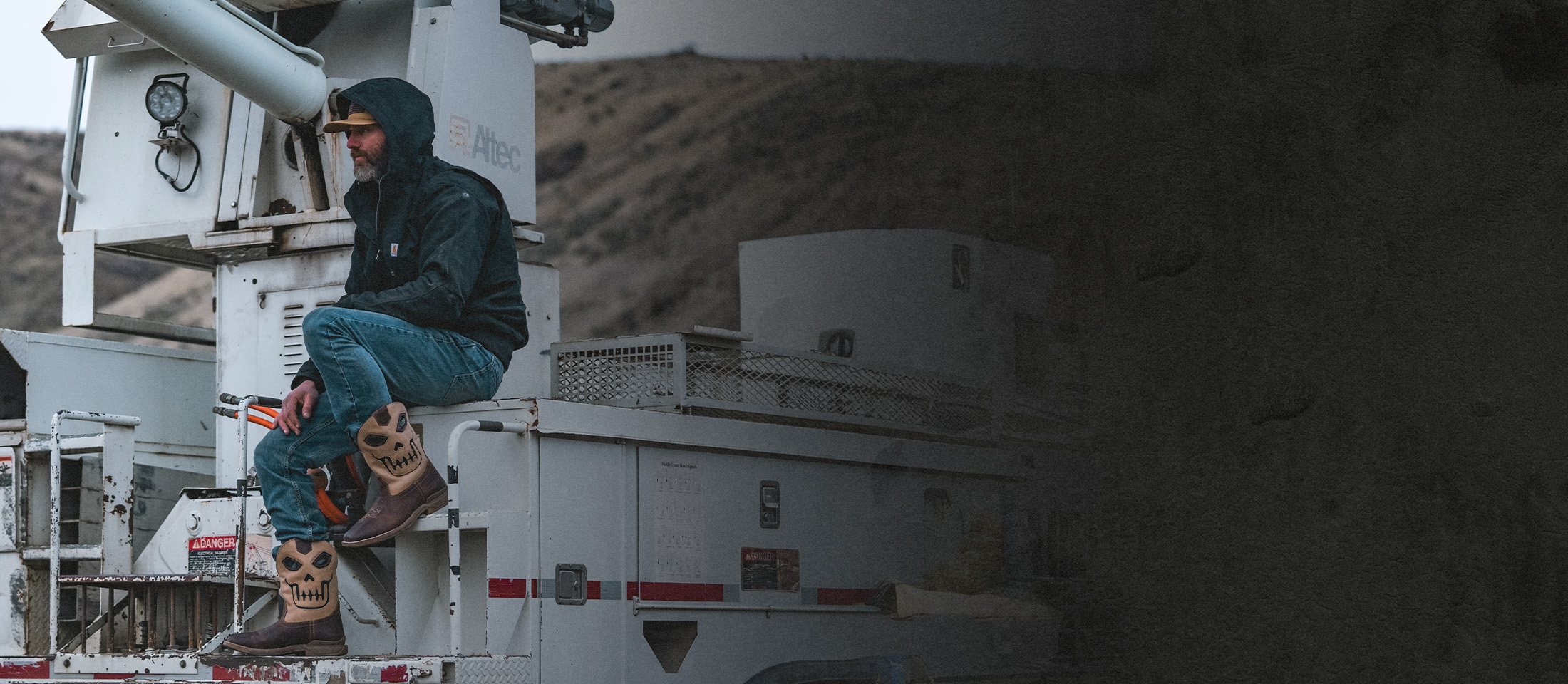 A man sitting on a truck wearing the Syphon western boots in tan.