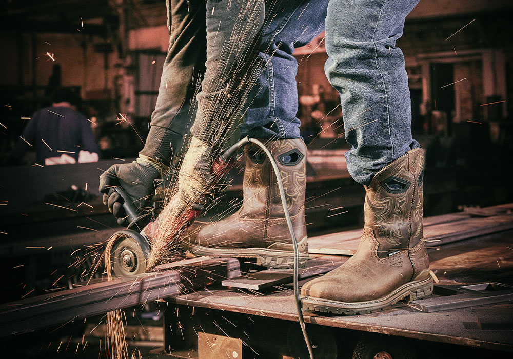 A man wearing the Stanton Comp Toe western boot in brown and working.