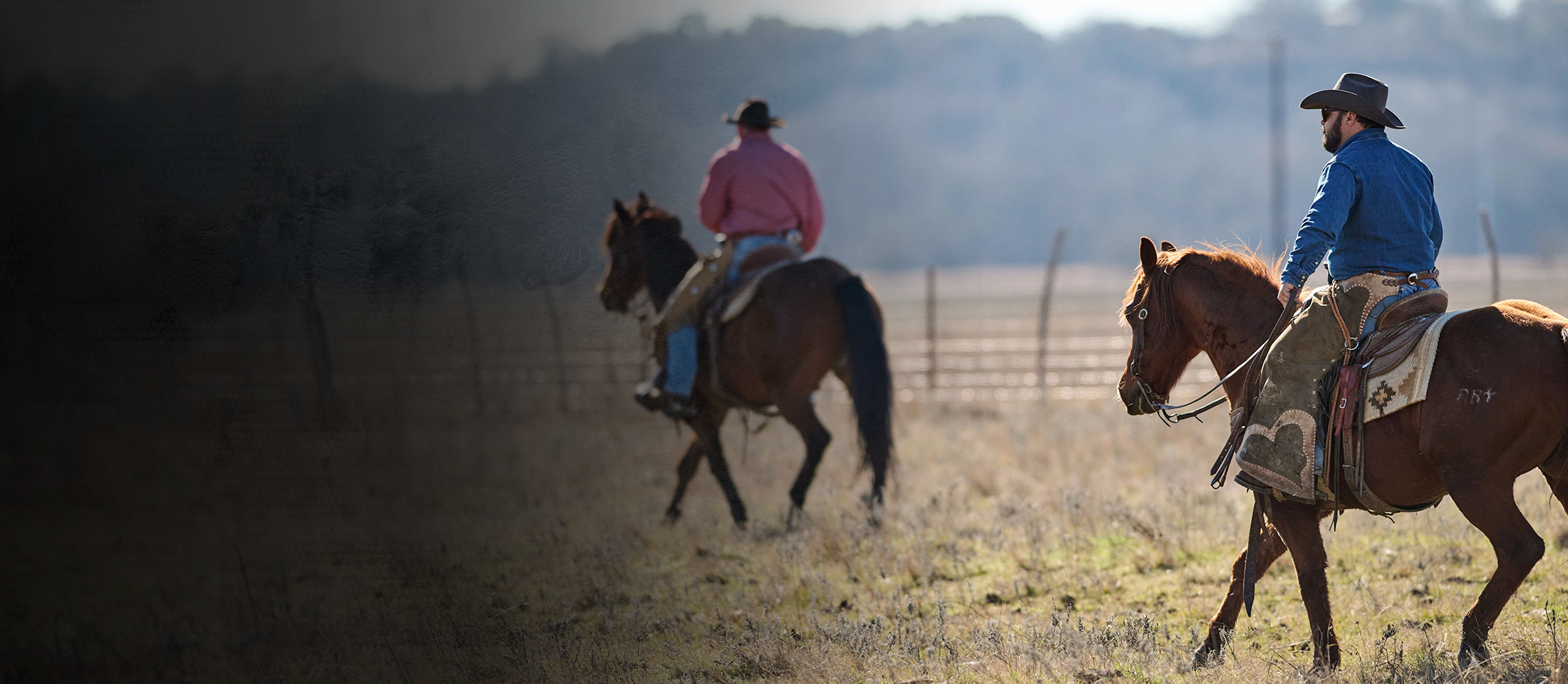 Two cowboys riding horses wearing Double-H Boots.