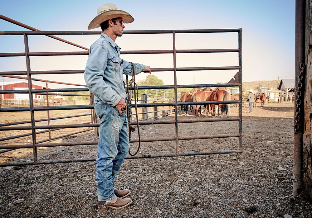 A cowboy wearing the Haywood western boot in brown.